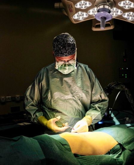 Dr Inan performing precise abdominal surgery with surgical instruments during a visceral surgical procedure.