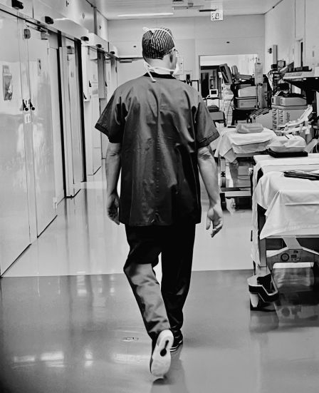 Dr Inan walking through the hospital corridor after a surgical procedure, reflecting clinical commitment and continuity of care.