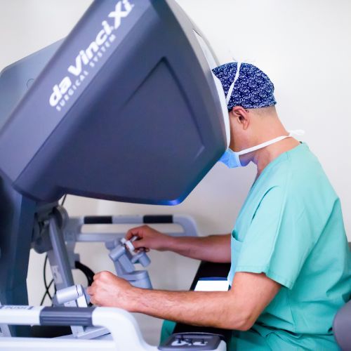 Surgeon operating a robotic console during robotic surgery in a sterile operating room in Geneva.